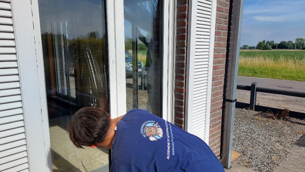 Ramenwasser Gent: medewerker van De Schoonmaakberen wast een raam